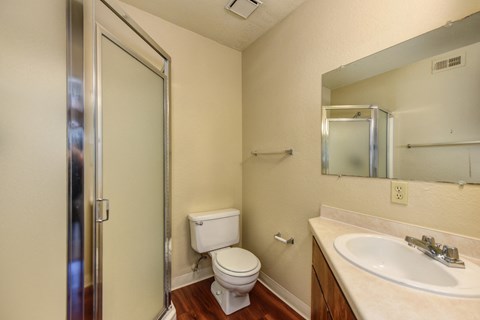 Bathroom with Toilet, Shower, Hardwood Inspired Floors and Sink